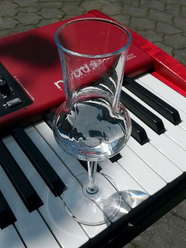 Schnapsglas auf Piano-Klaviatur